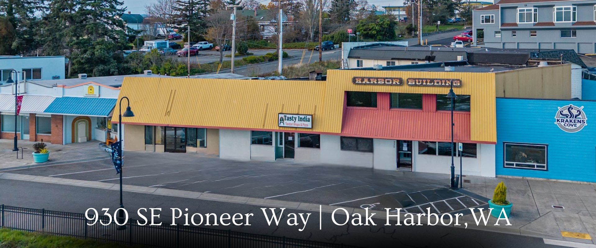 Exterior storefront view of the Harbor Building located at 930 SE Pioneer Way in downtown Oak Harbor, WA, featuring front angled parking, 89 feet of street frontage, and flexible commercial retail space for sale.